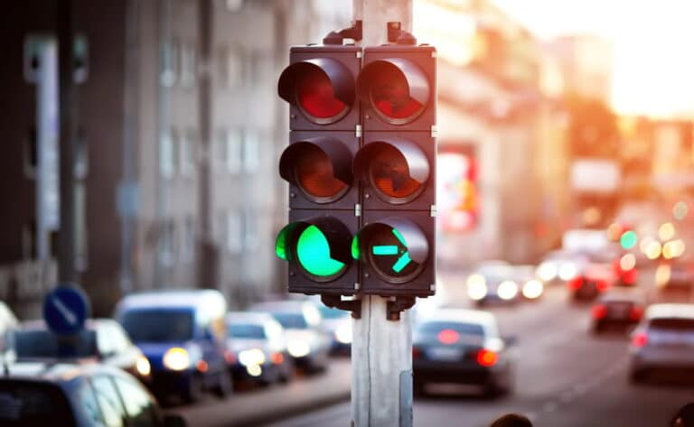 Image is of a busy city traffic light intersection, concept of how traffic violations may or may not appear on WA background check