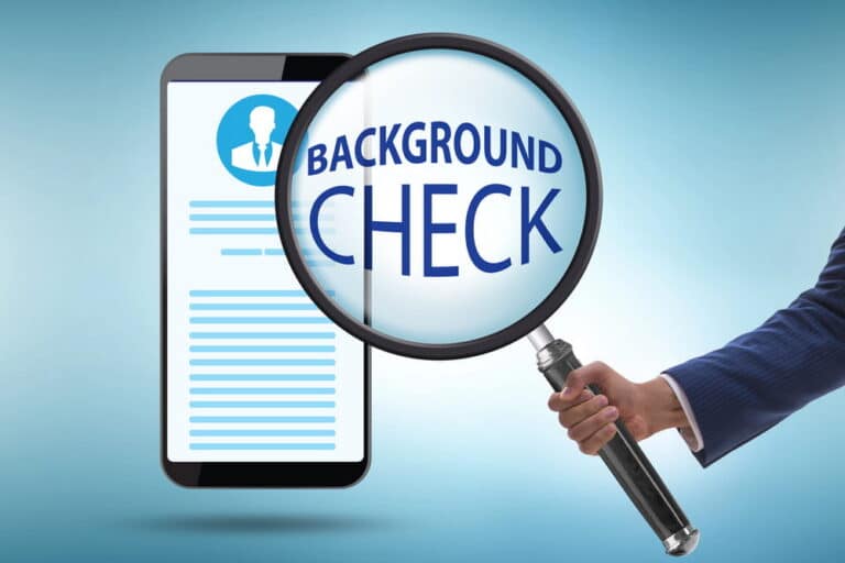 Image is of a magnifying glass highlighting a digital profile on a tablet, representing a staff background report review process in Washington schools
